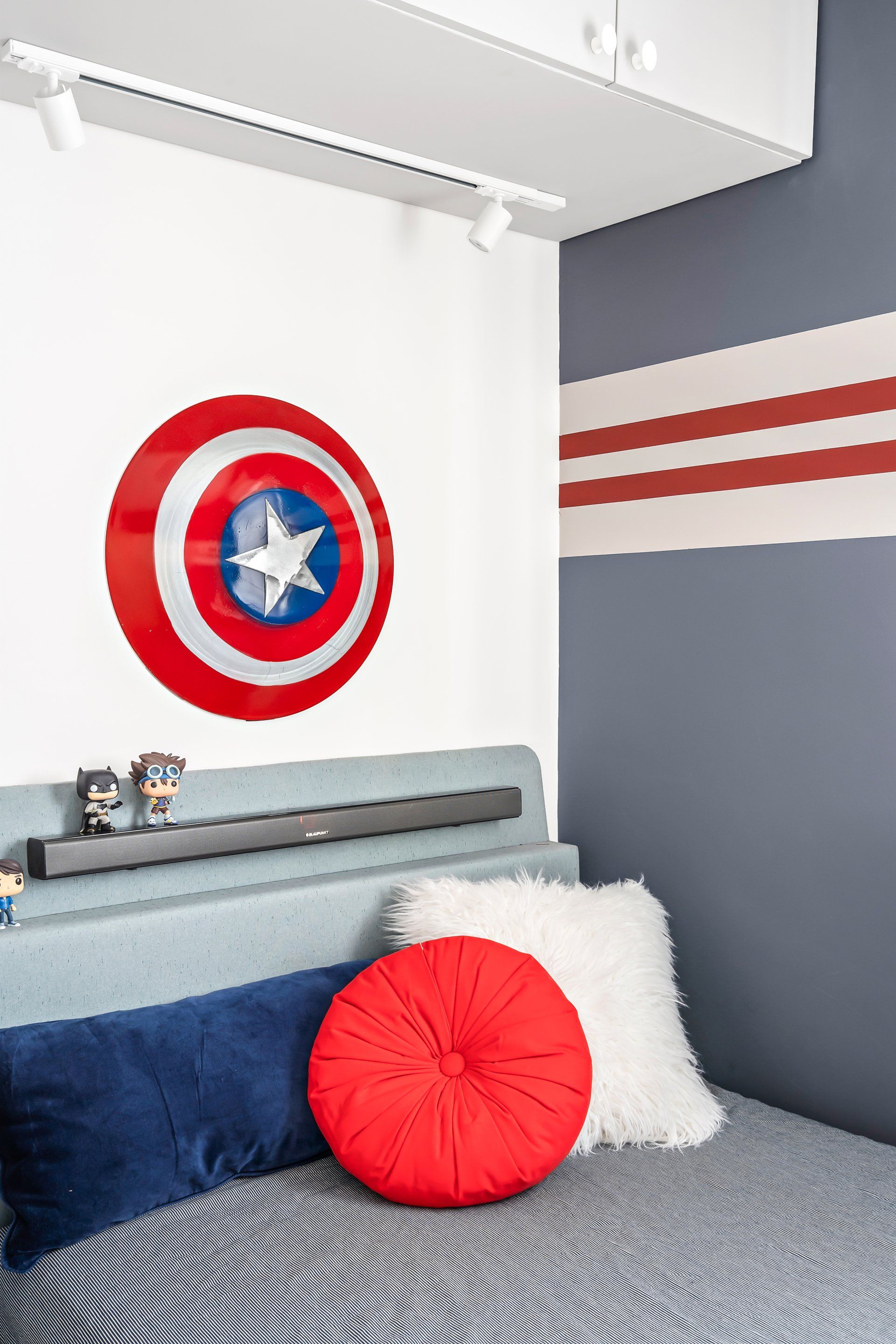 מעל המיטה תלוי המגן של קפטן אמריקה