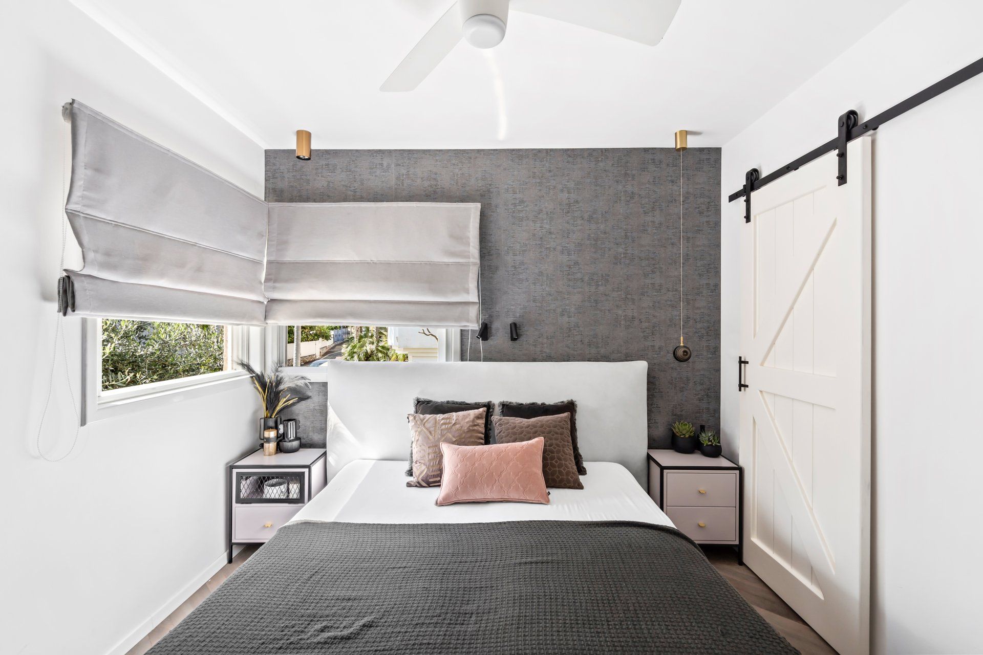 עיצוב חדר שינה בסגנון יוקרתי עם גב מיטה לבן וקיר עם טפט אפור