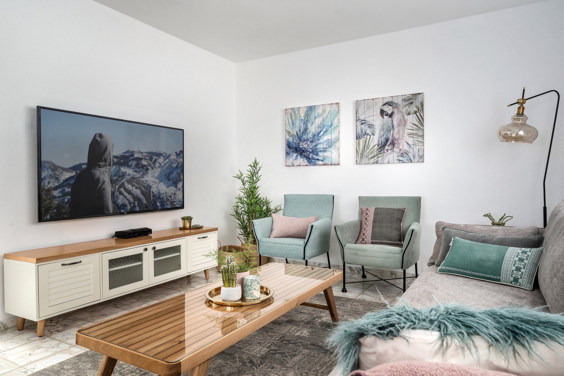 סלון בגוונים של ירוק וורוד עם שולחן סלון מעץ ואומנות קיר