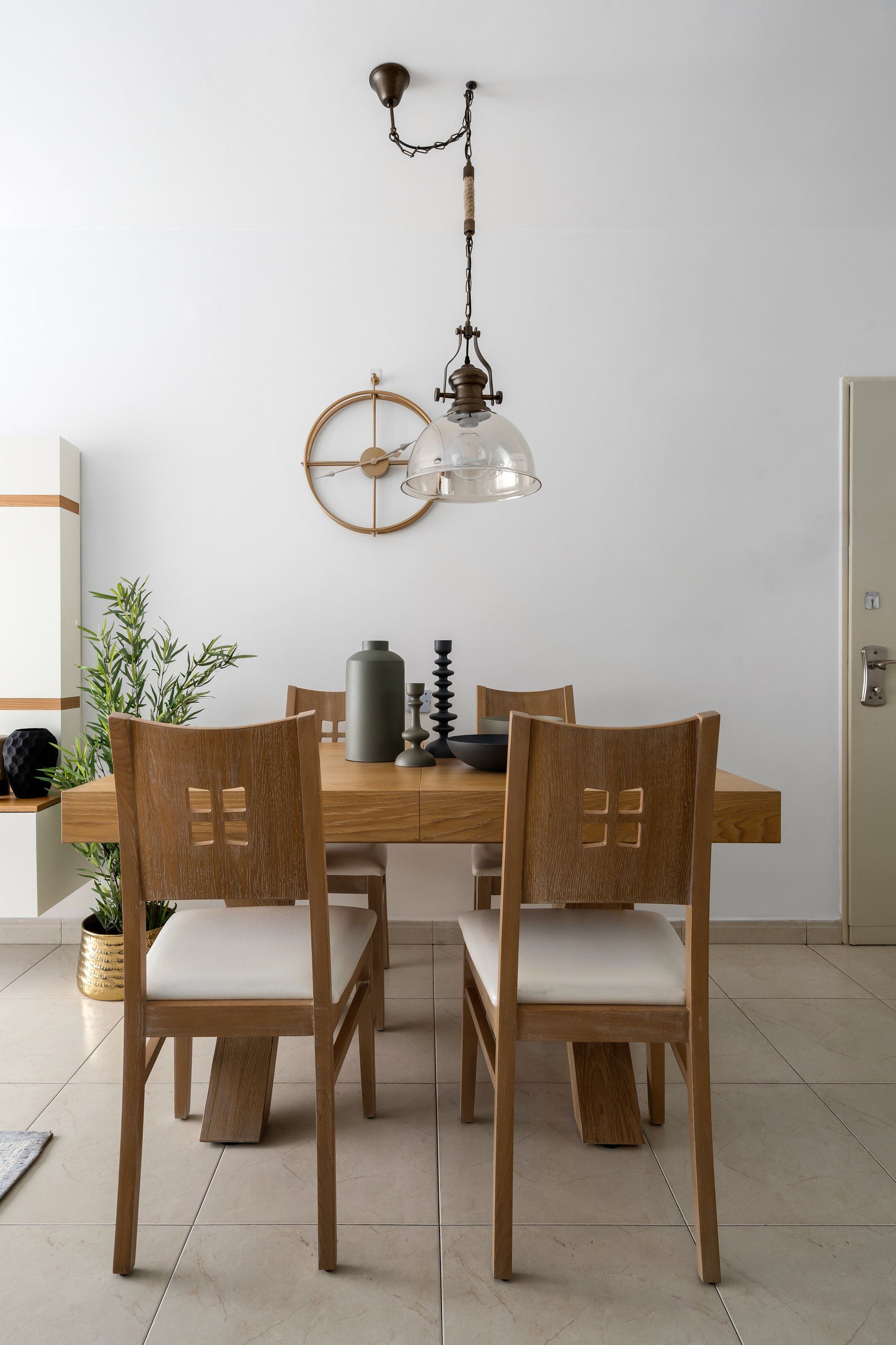 פינת אוכל מעץ ושעון זהב מודרני ומנימליסטי על הקיר