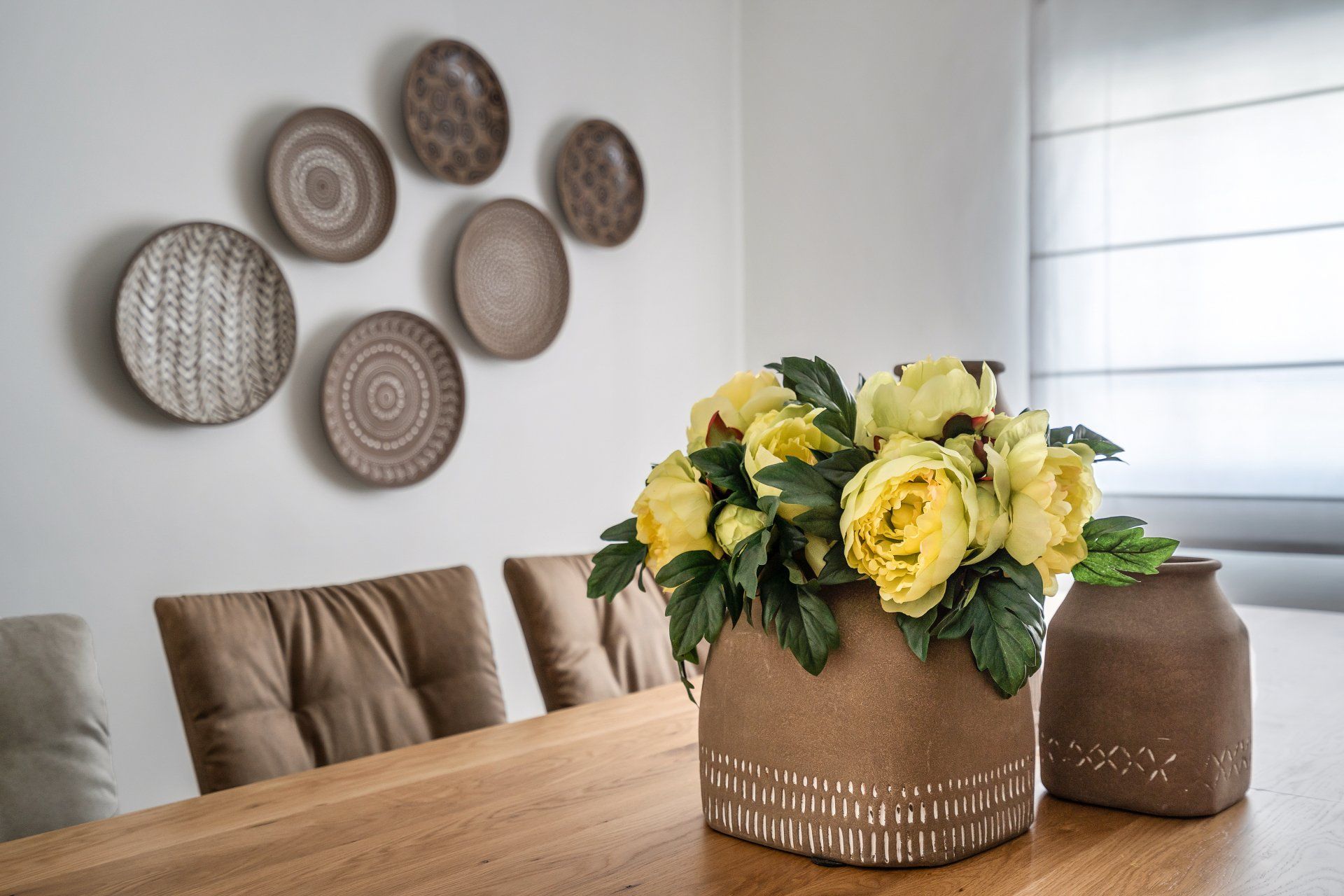 פינת אוכל בגוונים חומים עם אומנות קיר מאחור