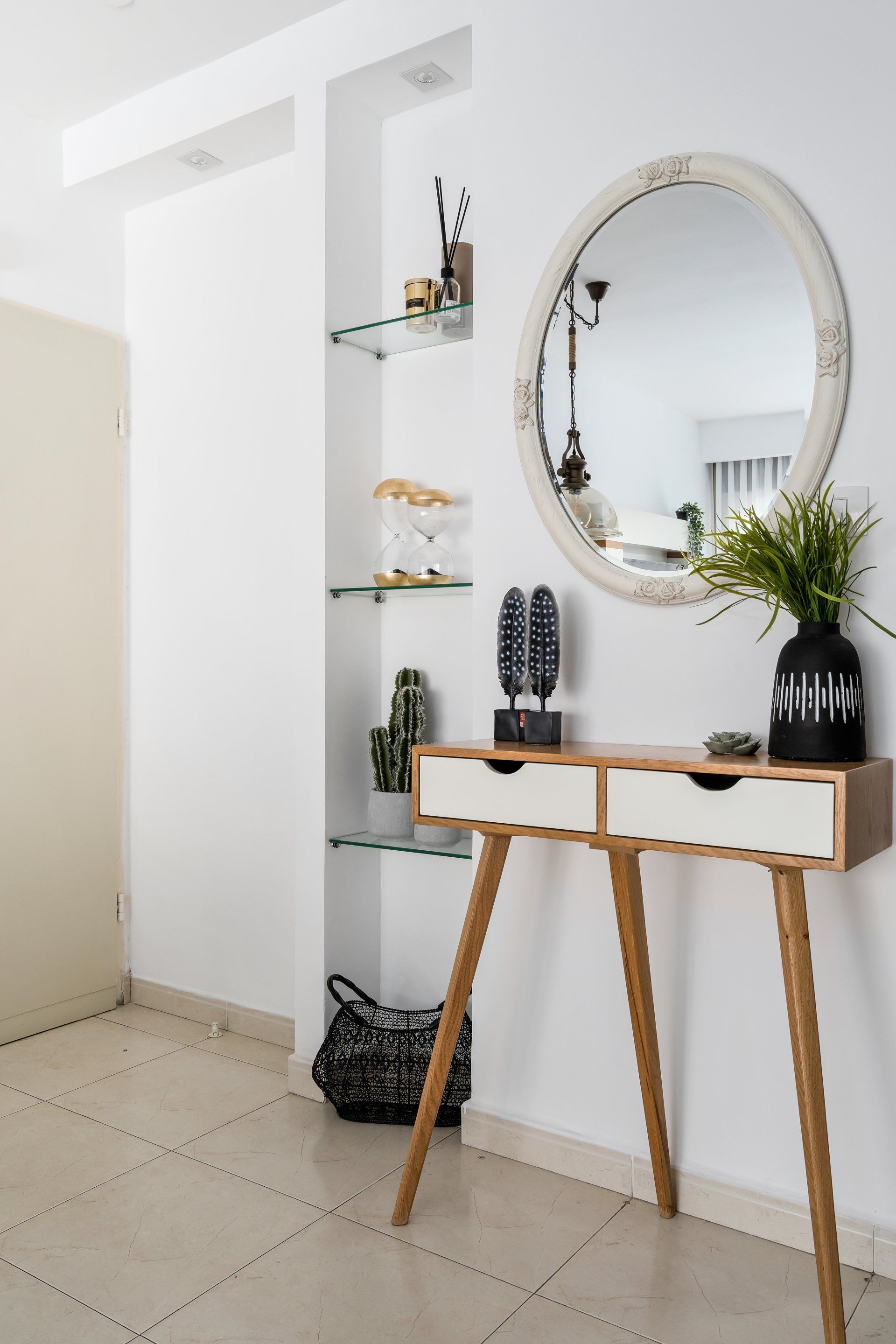 קונסולת כניסה עם פסלים דקורטיבים ומראת כניסה