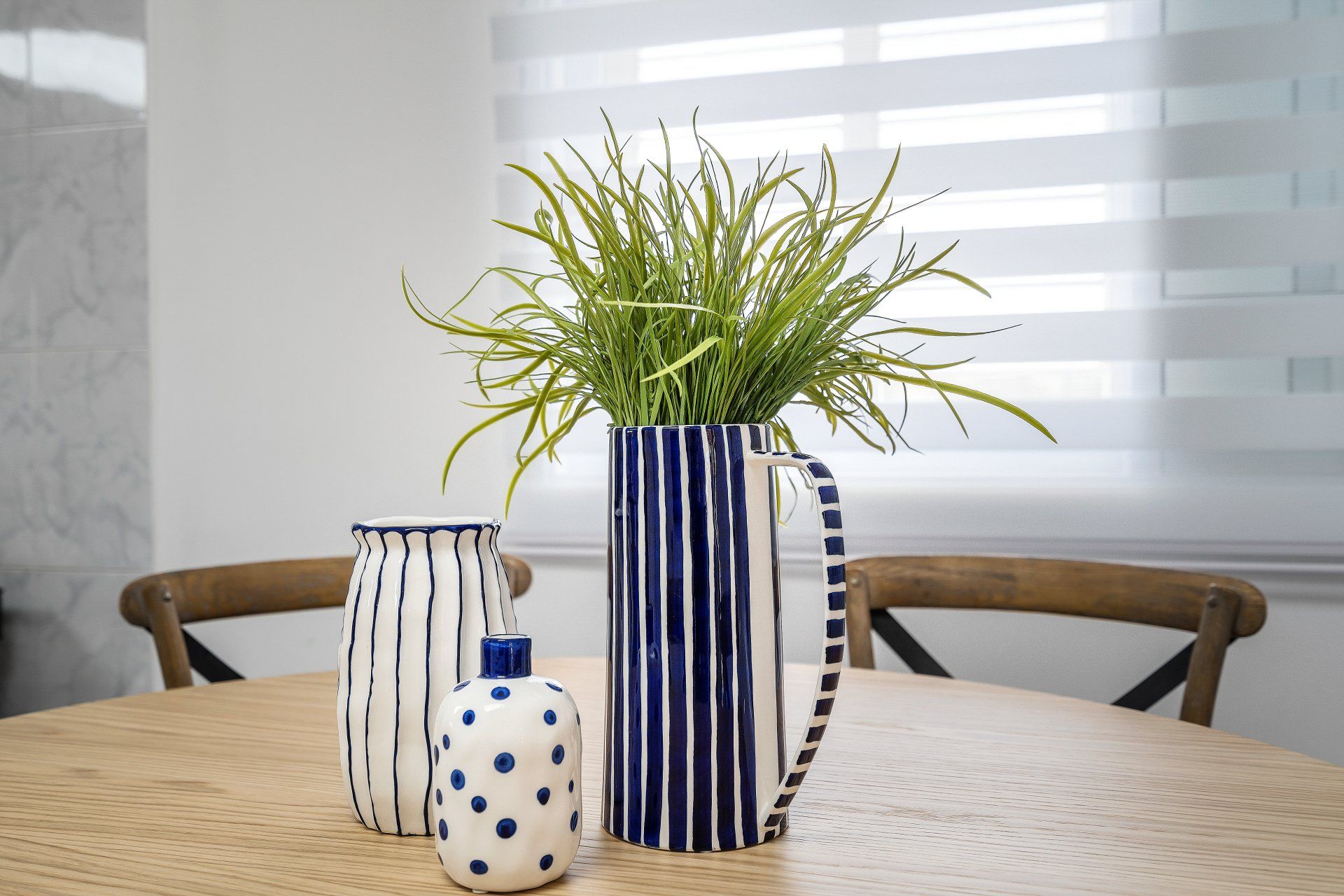 קנקן קרמיקה בגוונים של כחול ולבן עם צמחיה