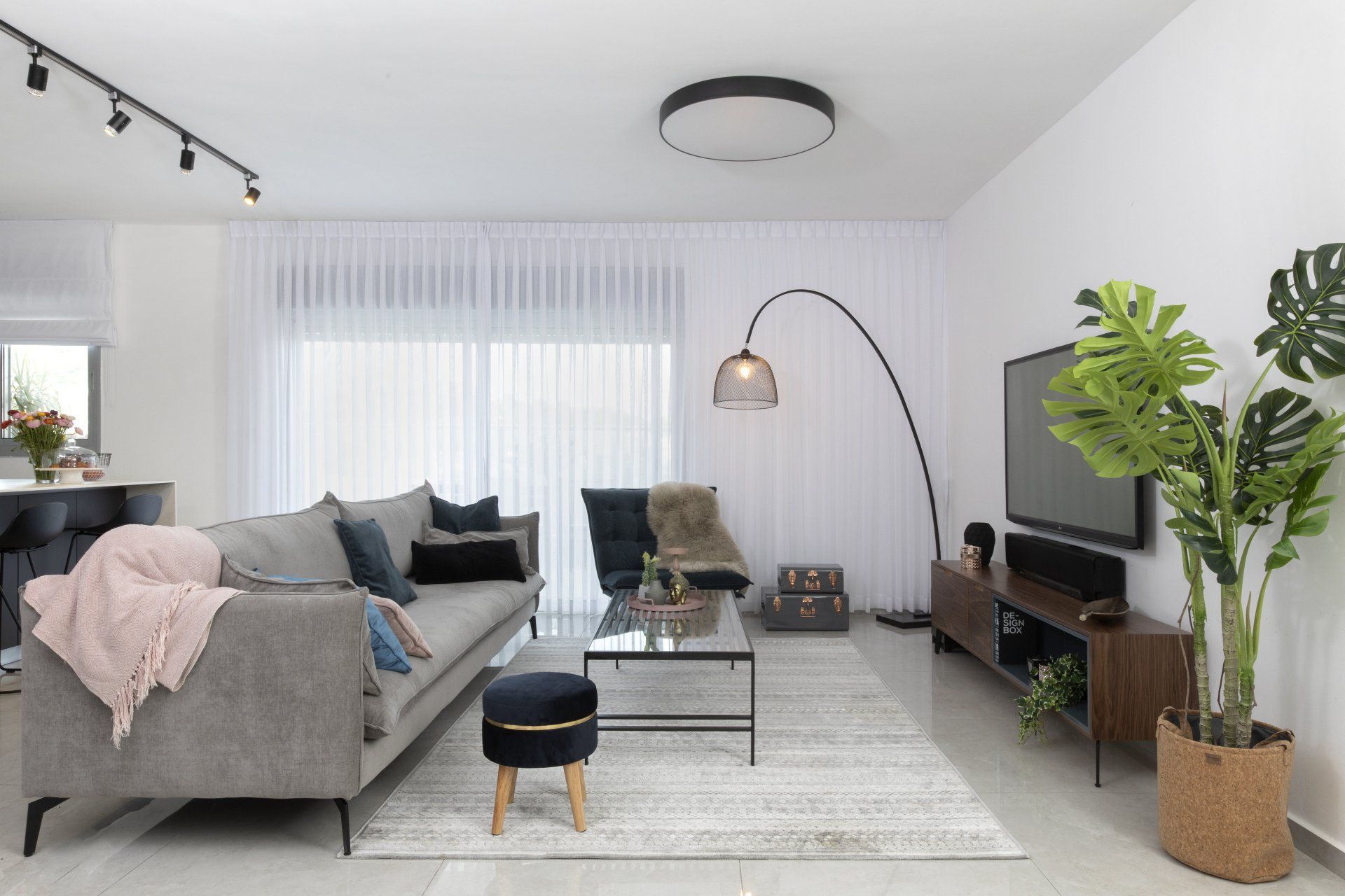 סלון בדירת קבלן עם שטיח לבן וגוף תאורה מעוצב