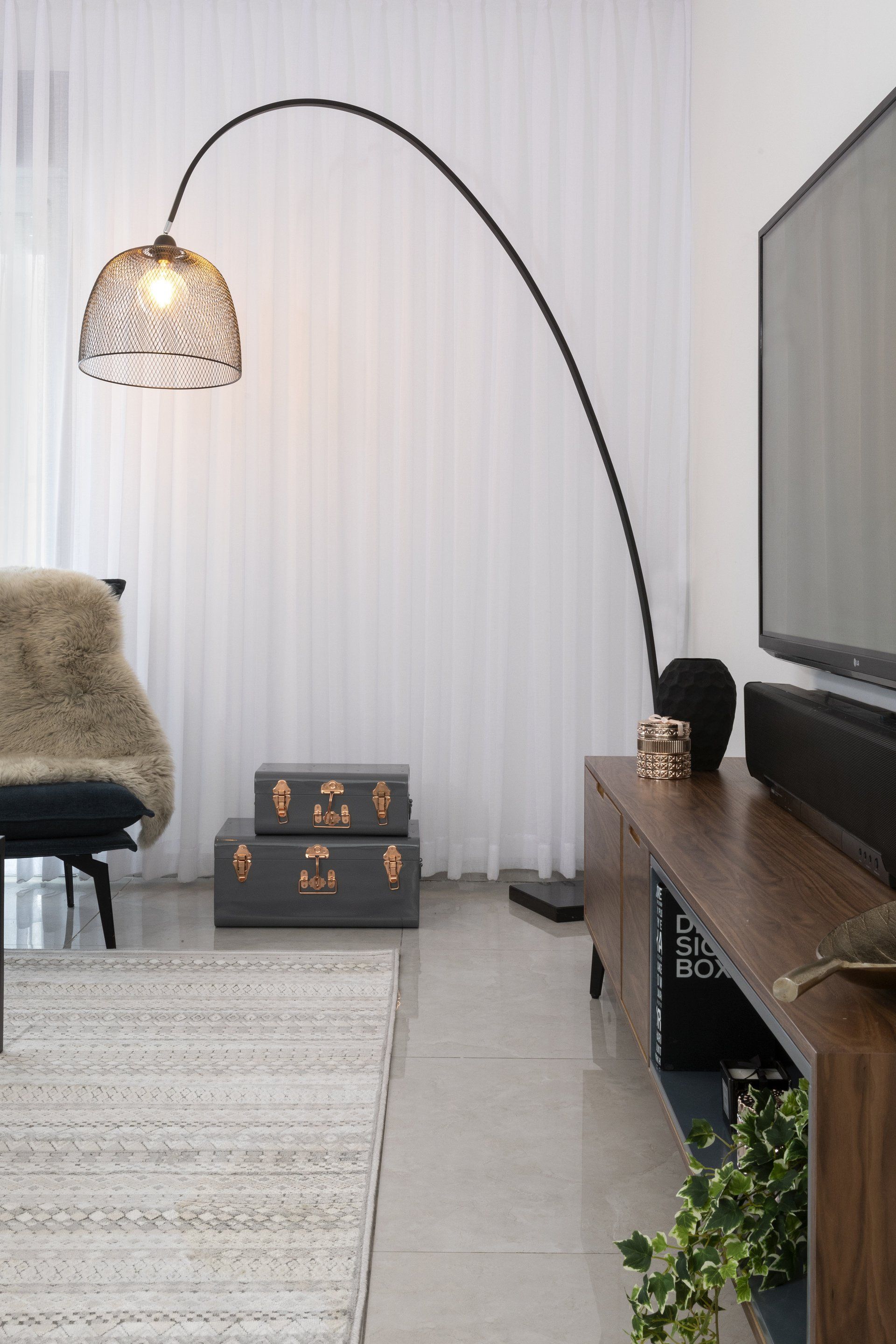 מנורת קריאה גדולה עומדת בסלון בצורה קשת