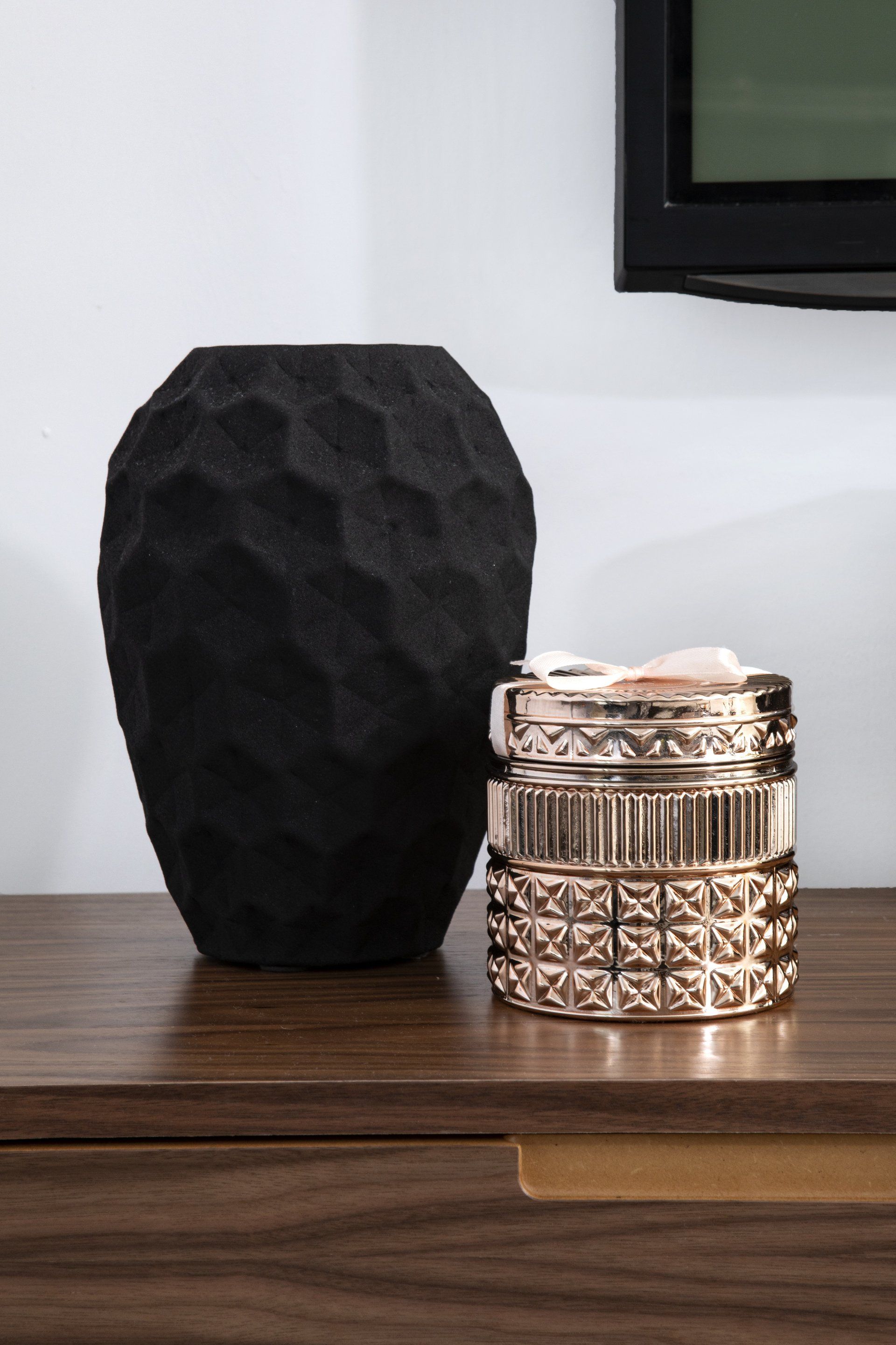 אגרטל שחור על שידה חומה