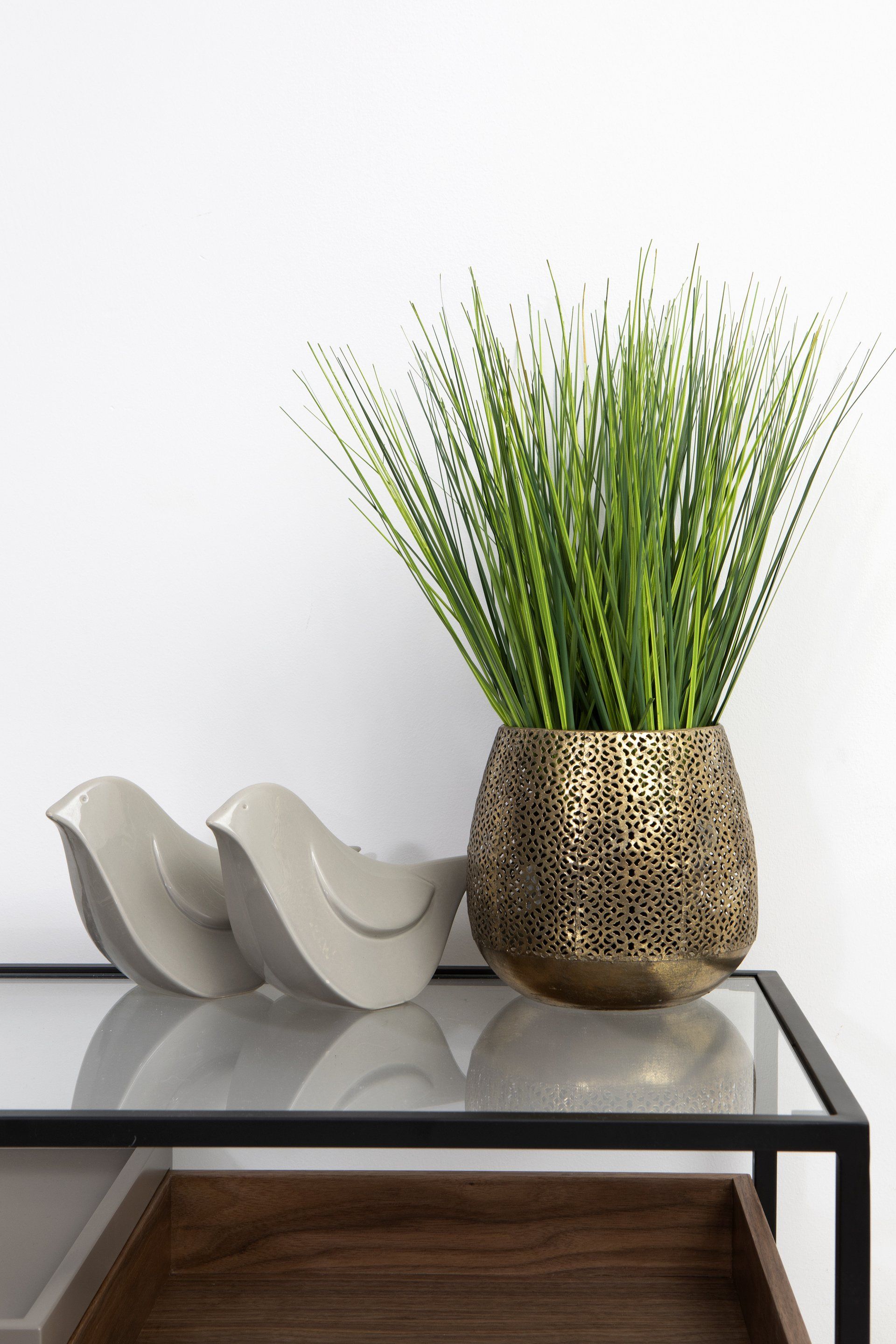 אגרטל זהב עם עלים ירוקים וזוג ציפורים על קונסולת כניסה