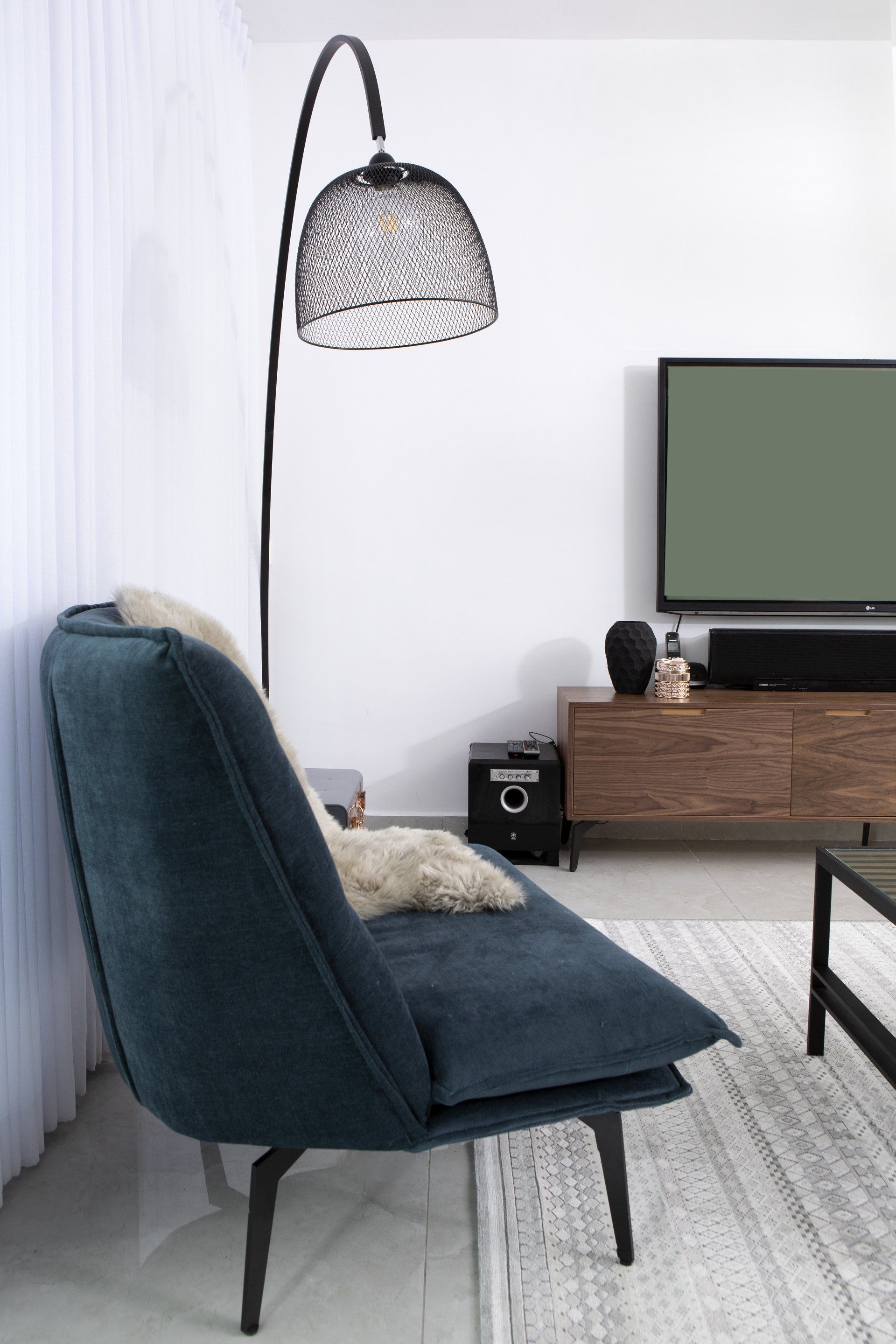 כורסה כחולה כהה עם מנורת קריאה מעוצבת