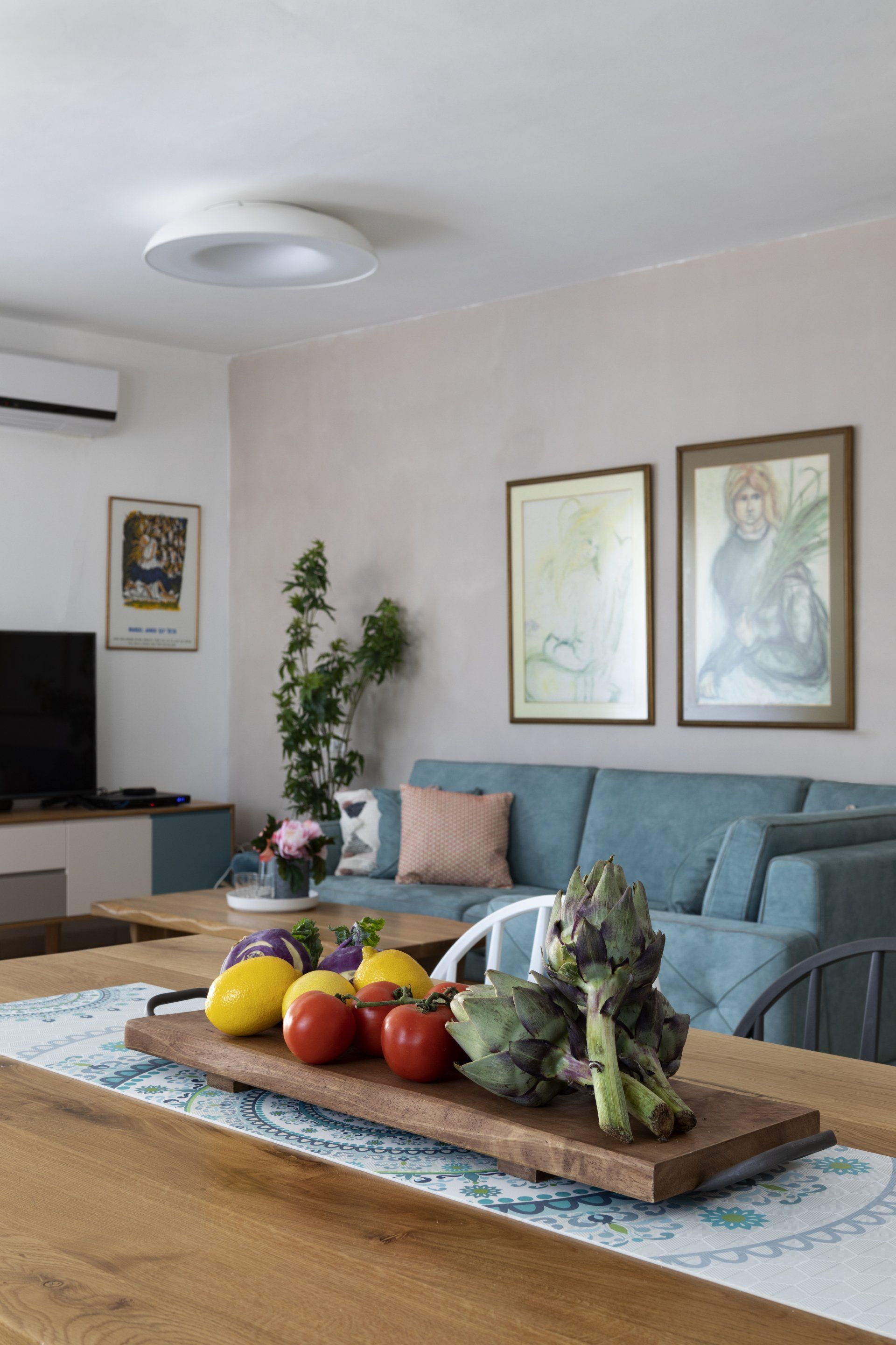 פינת אוכל וסלון בכחול עם 2 תמונות מעל ספה