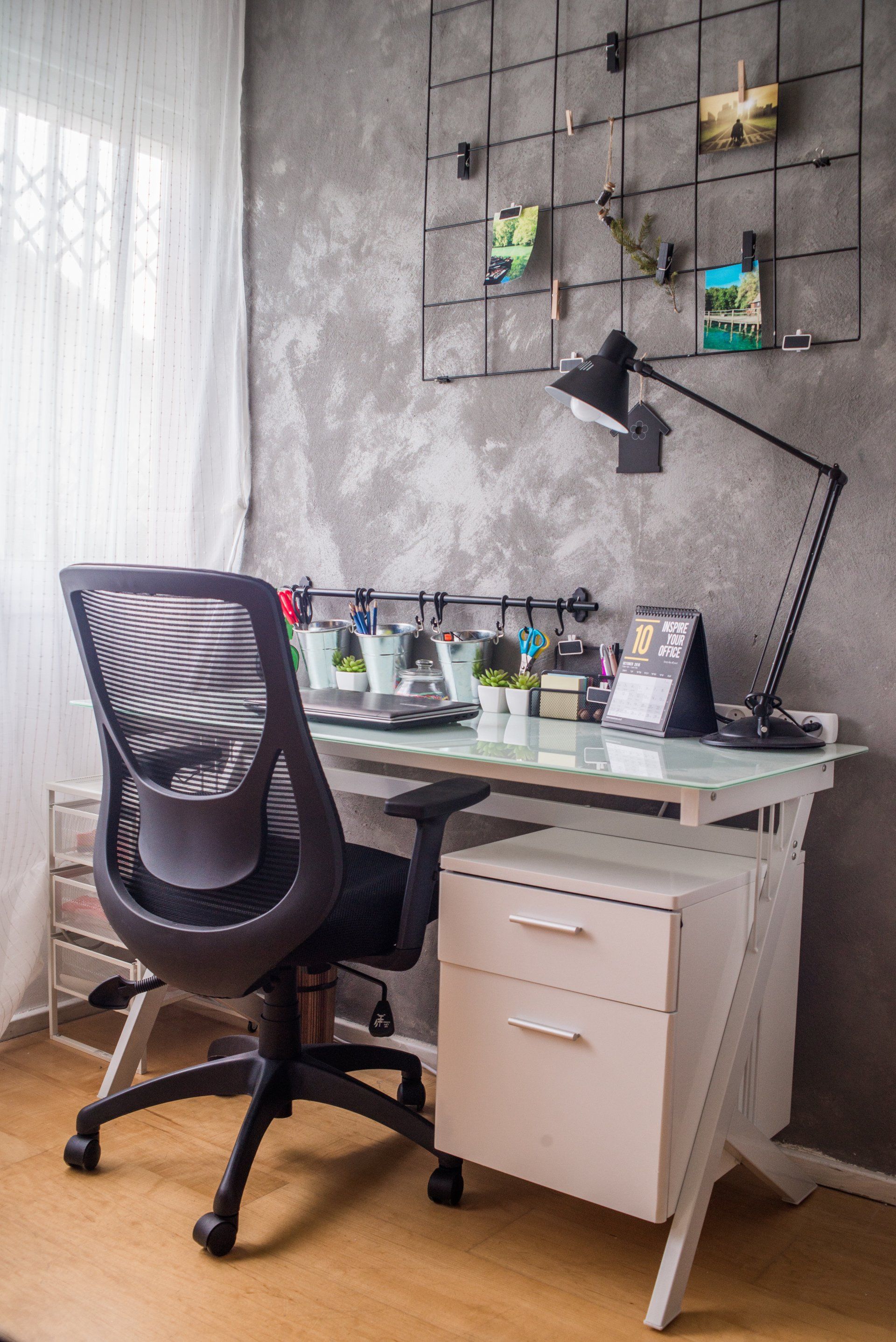 פינת עבודה עם קיר צבוע באפור בטון ומנורת קריאה שחורה