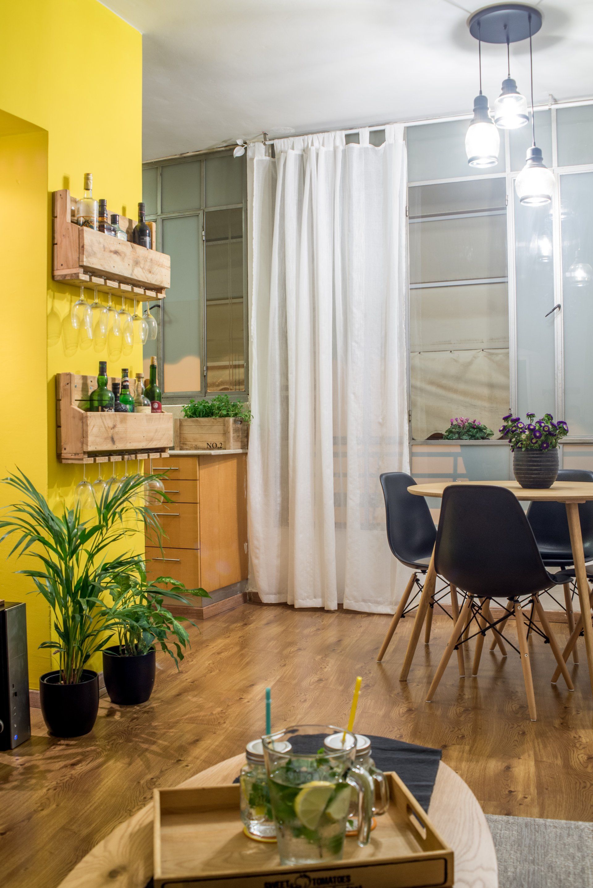 קיר צהוב ופינת אוכל מעץ