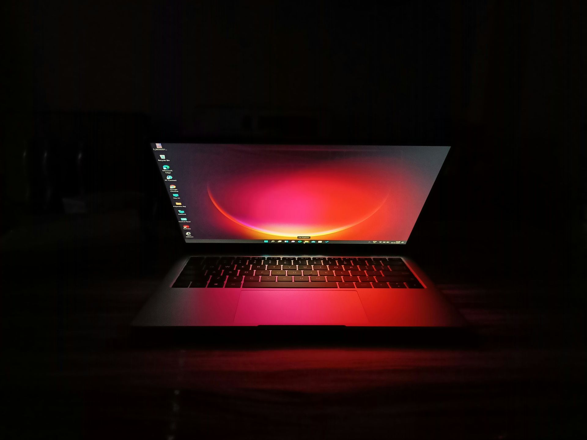 Red-lit laptop floating on a black background