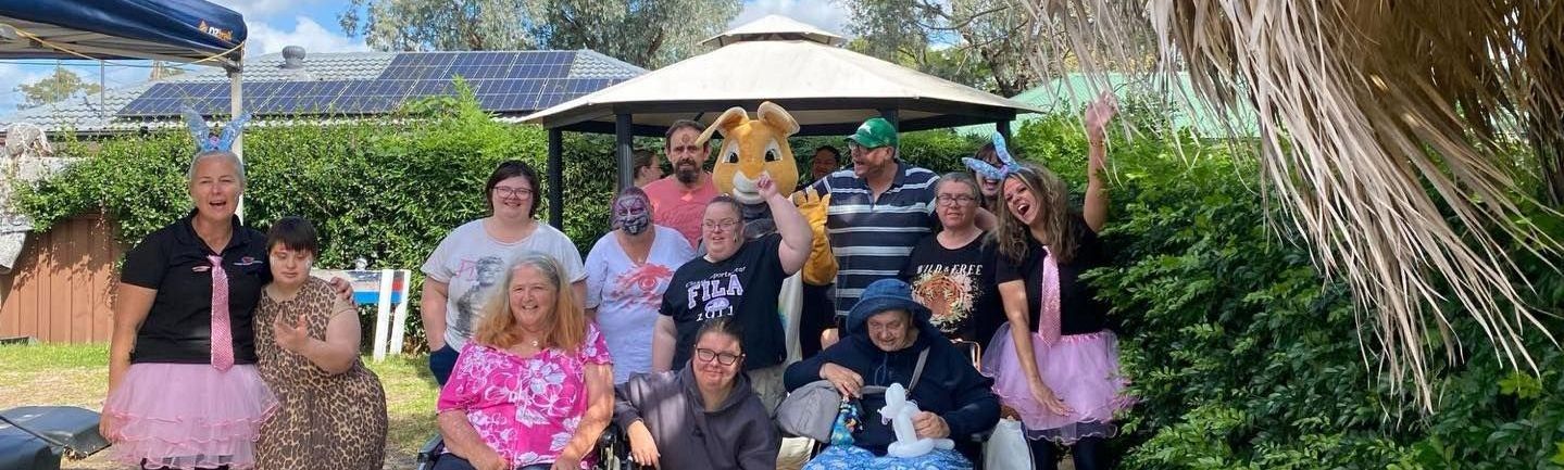 Day centre group photo for Easter event. A group of people are posing for a picture in front of a gazebo.