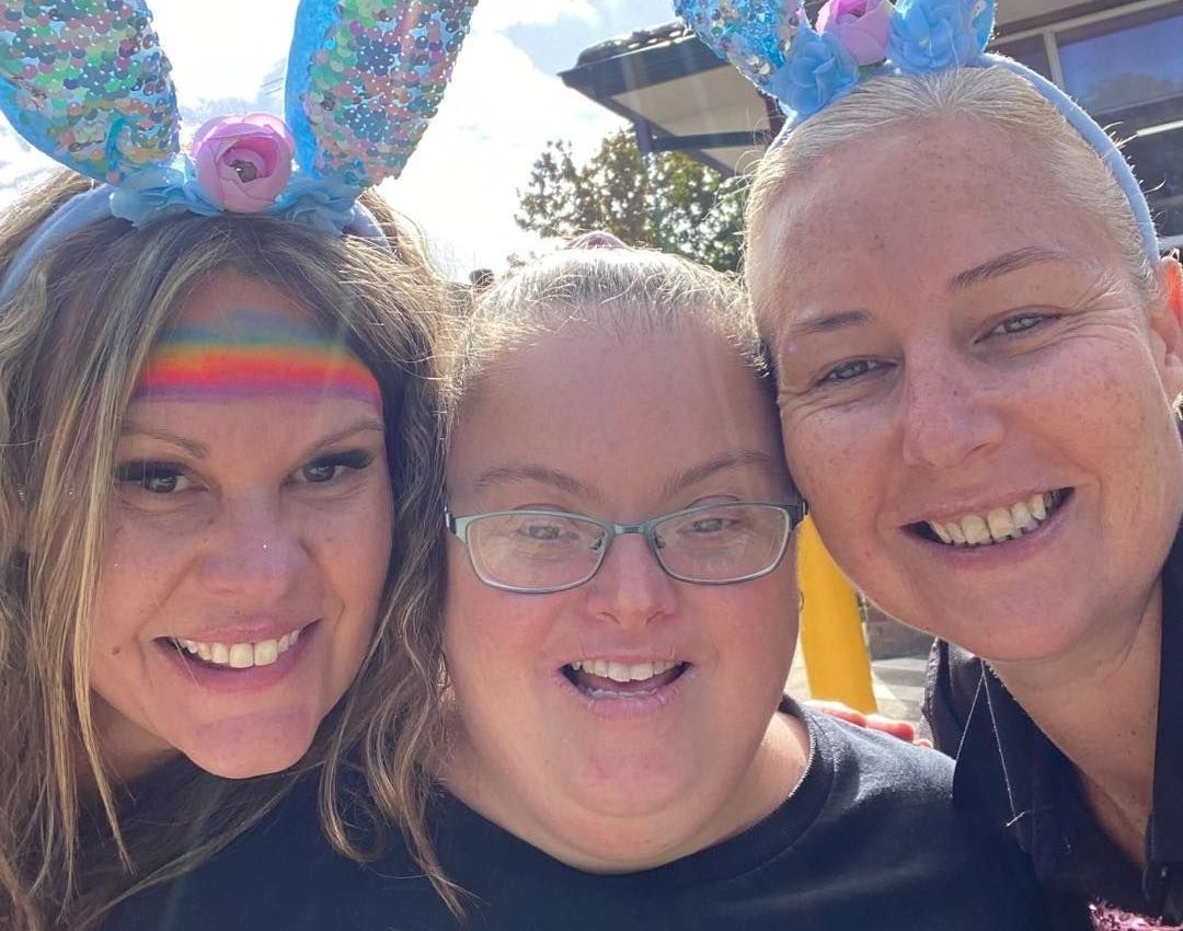 Three women wearing bunny ears are posing for a picture.