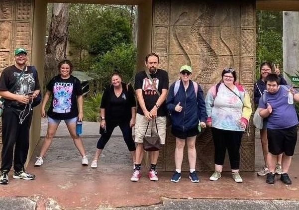 Community group out to the Reptile Park. Group posing at front entrance.