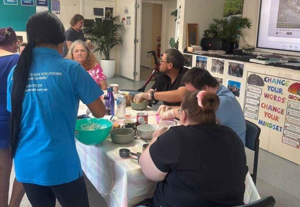 A group of people are sitting around a table with a sign that says change your words