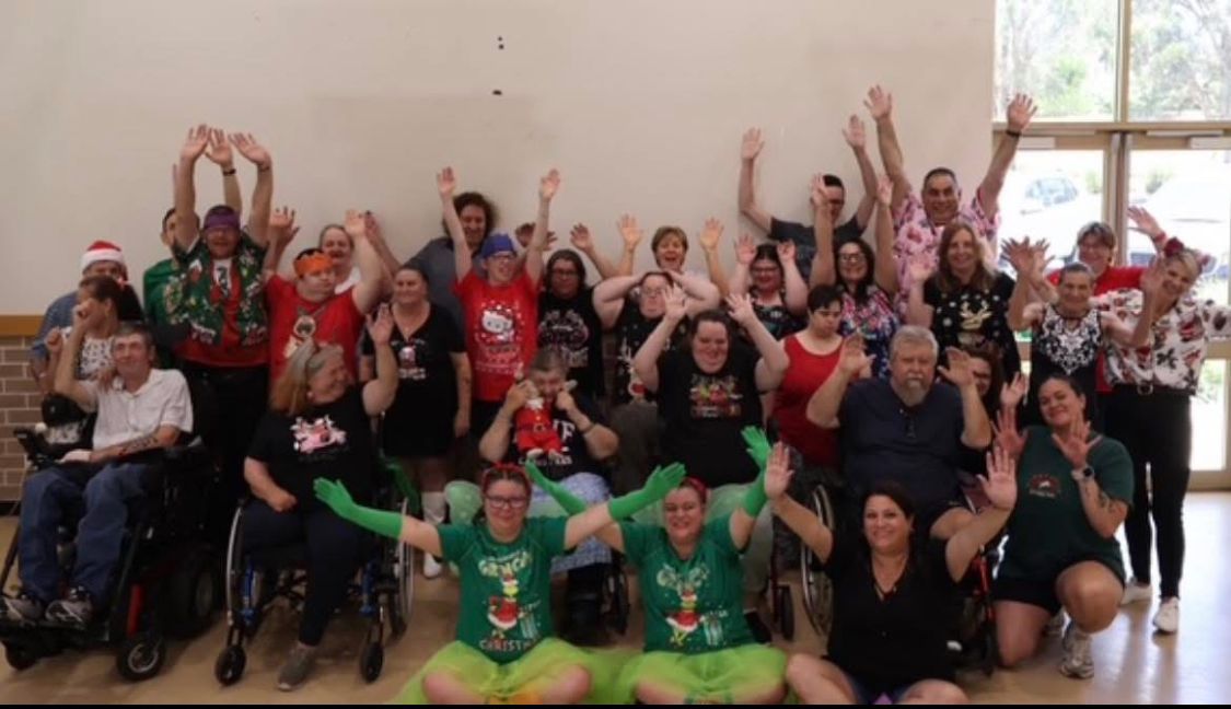 A group of people are posing for a picture with their hands in the air.