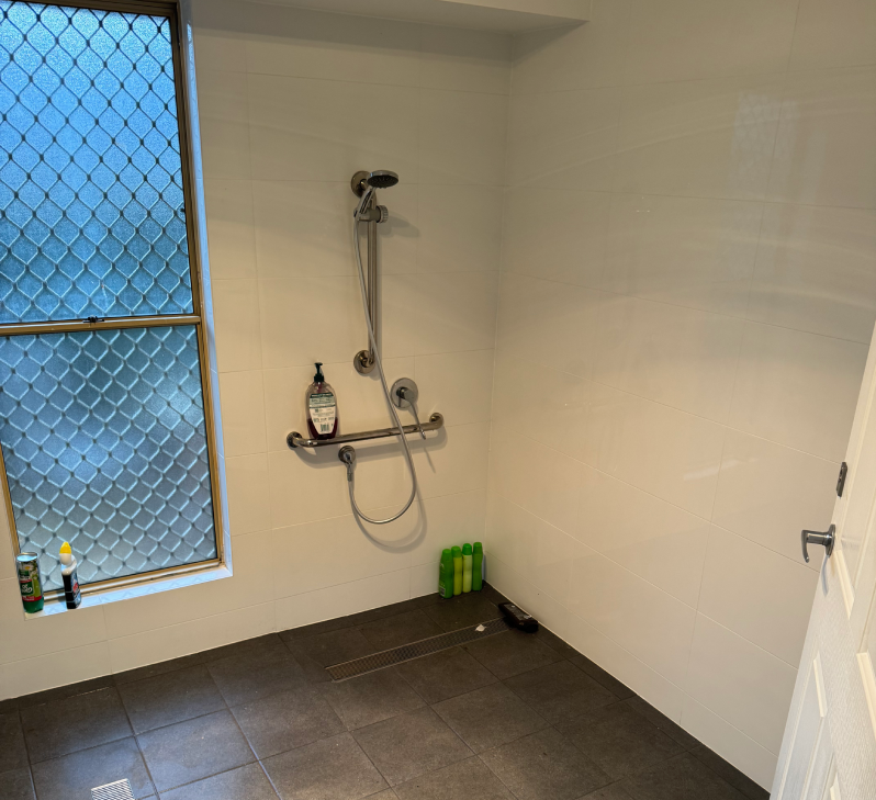 A modified NDIS bathroom with a shower and a window for disability access.