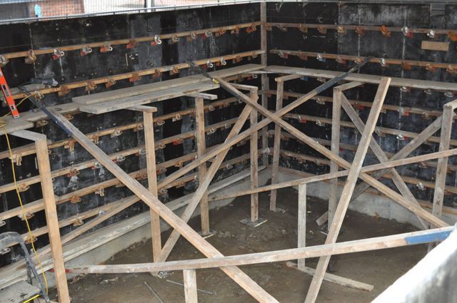a wooden structure is being built in front of a wall