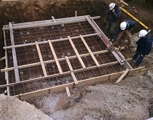 a group of construction workers are working on a concrete base