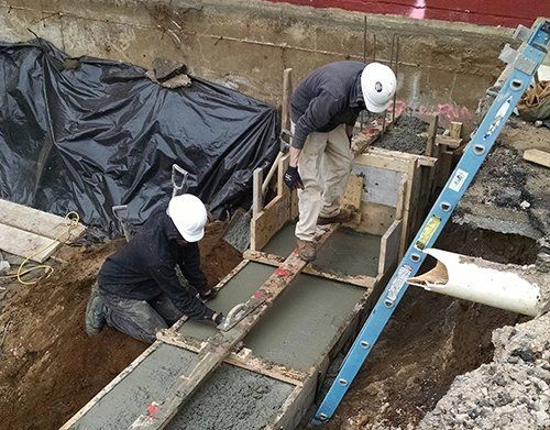 a group of construction workers are working on a concrete project