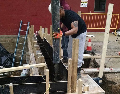 a man is pouring concrete into a concrete wall