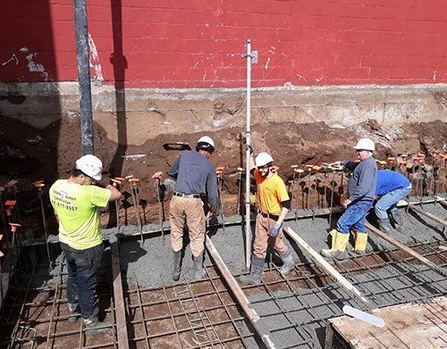 a group of construction workers are working on a concrete base
