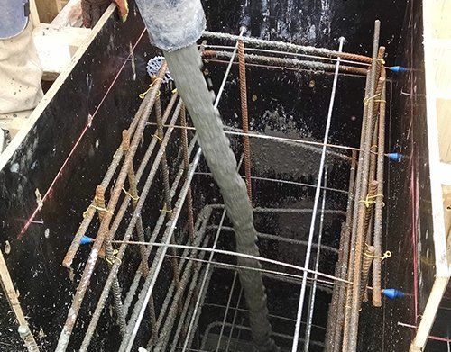 a person is pouring concrete into a hole in a building