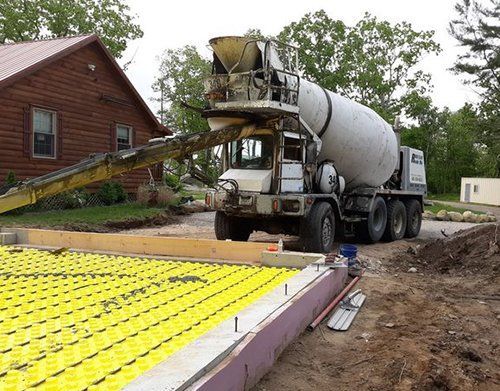 a cement truck is pouring concrete into a foundation