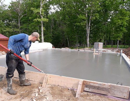 a man is working on a concrete floor with a shovel