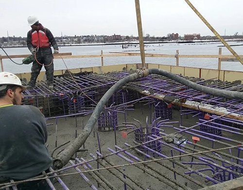 two construction workers are working on a bridge over a body of water