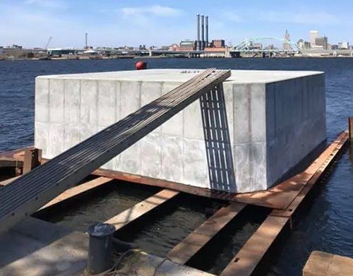 a large concrete block is sitting on top of a wooden platform in the water