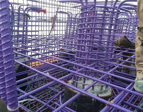 a person is standing in a pile of purple steel bars