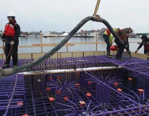 a group of construction workers are working on a concrete floor