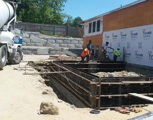 a concrete mixer is pouring concrete into a hole in the ground