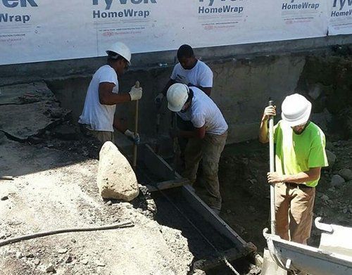 a group of construction workers are working on a foundation