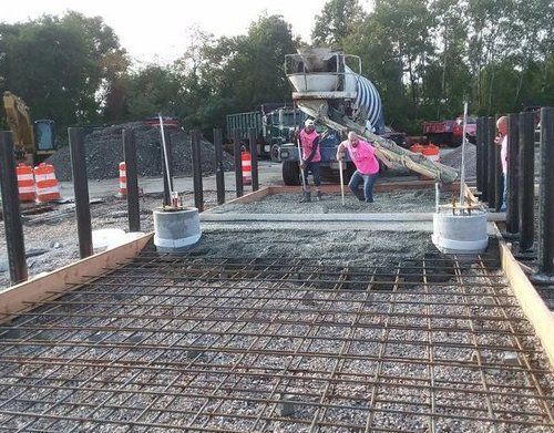 a concrete truck is pouring concrete on a construction site
