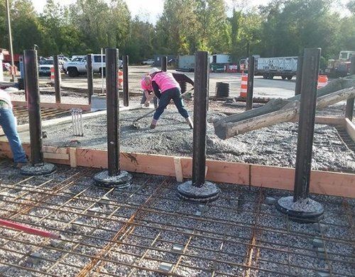 a woman in a pink hard hat is working on a construction site