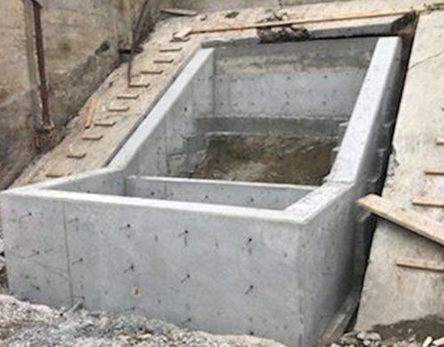 a large concrete structure is being built on top of a dirt hill