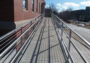 a ramp with a metal railing leading to a brick building