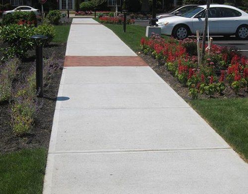 a white car is parked on the side of a sidewalk