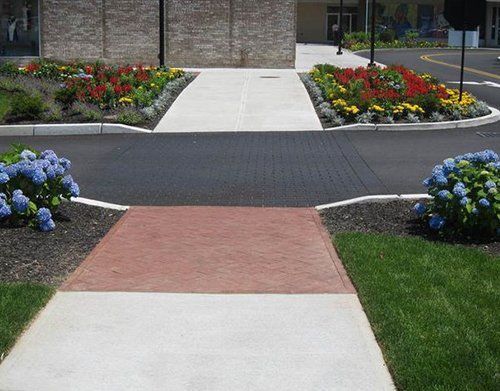 a walkway with flowers on the side of it