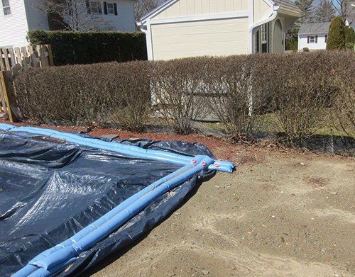 a blue pipe is laying on the ground in front of a house