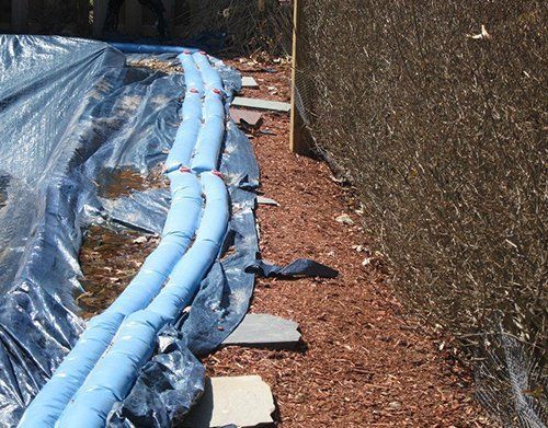 a row of blue bags are sitting on the ground next to a fence