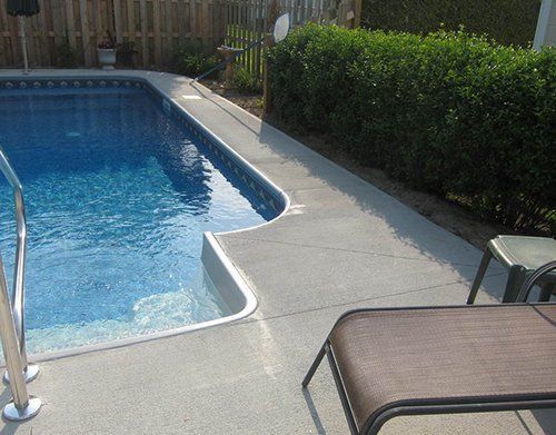 a swimming pool is surrounded by a fence and a chair