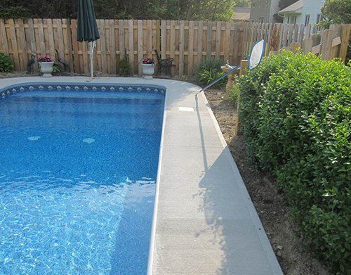 a swimming pool with a wooden fence surrounding it