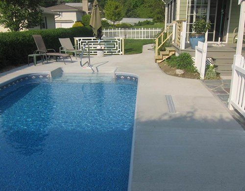 a large swimming pool is in the backyard of a house