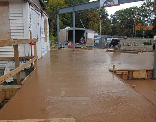 a man is working on a concrete floor in front of a building