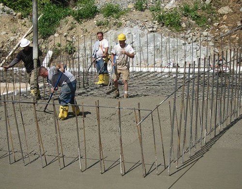 a group of construction workers are working on a concrete floor