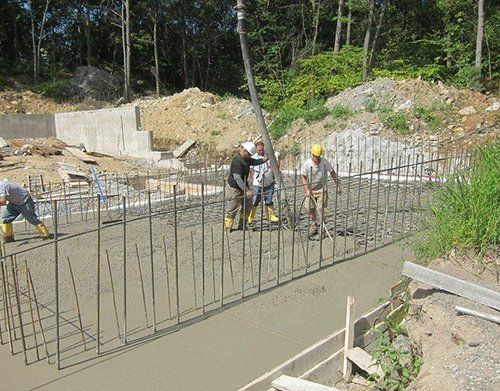 a group of construction workers are working on a concrete wall